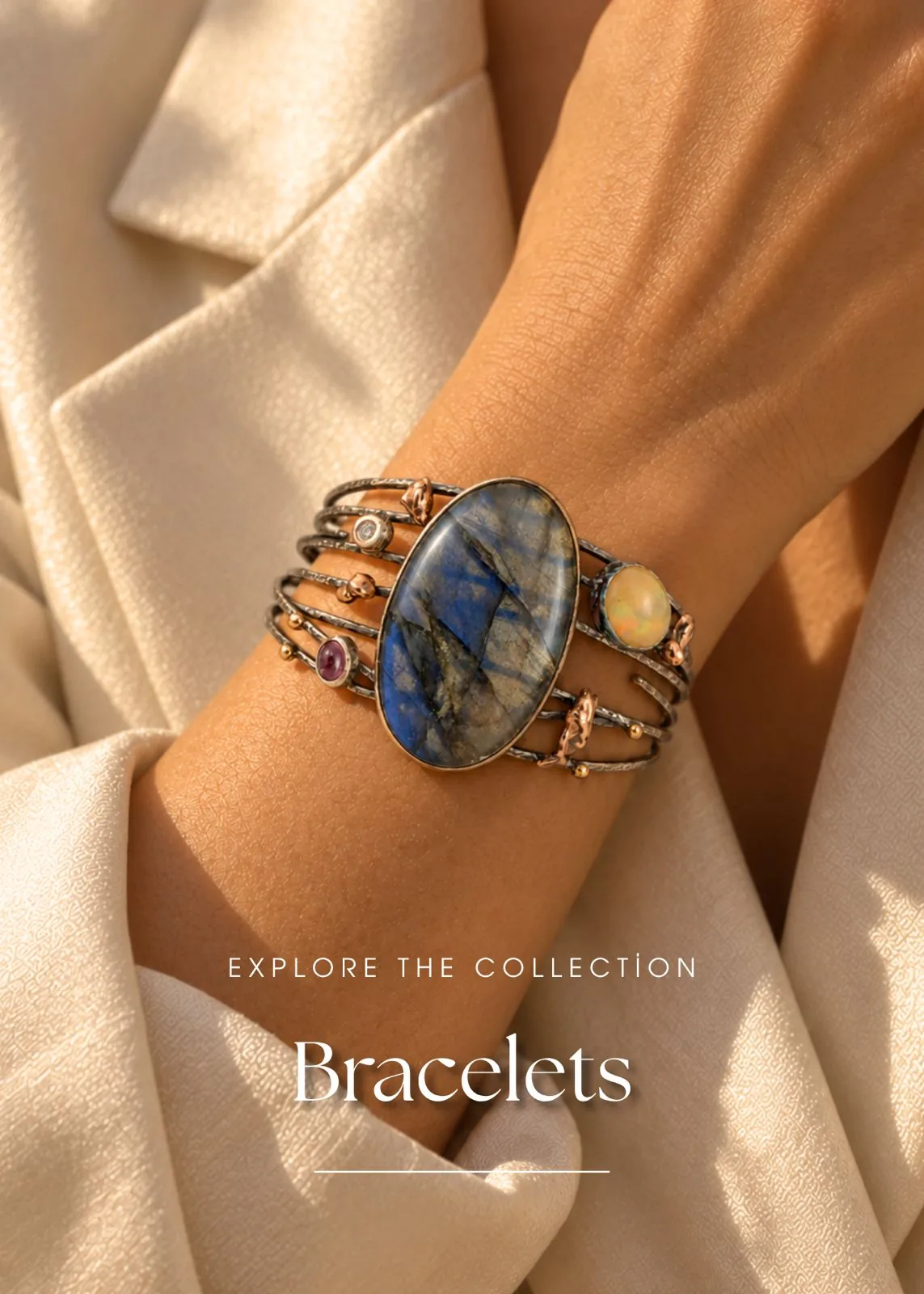 Wrist wearing an oxidized silver multi-band cuff bracelet with a large oval blue gemstone, opal and rose gold accents - Silverely bracelets collection
